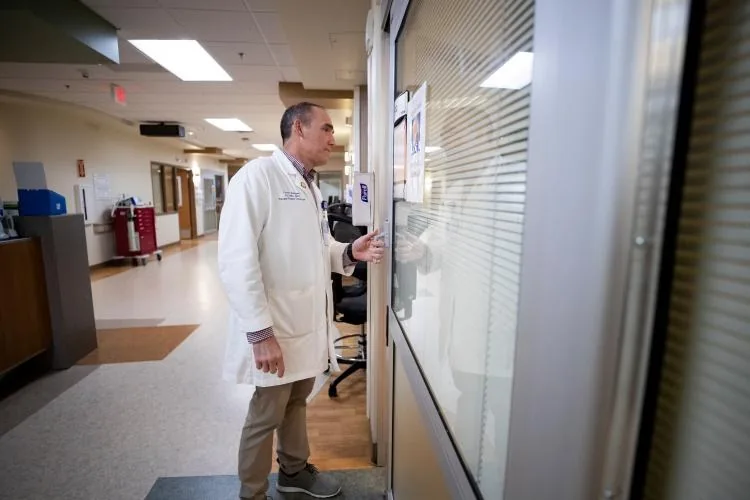 Dr. Rodriguez rounding, about to enter a patient's room